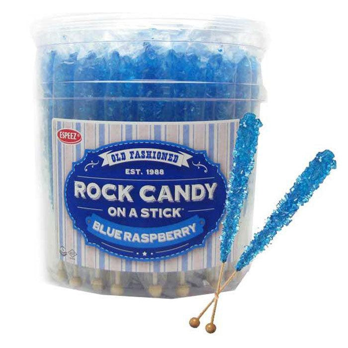 Front. view of a display jar full of blue raspberry rock candy. There are two sticks of candy in front of the jar.
