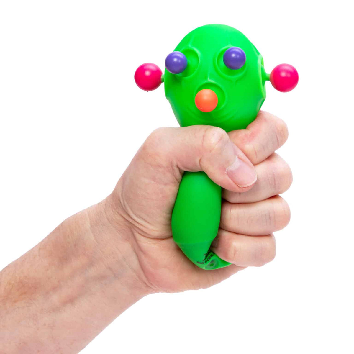 Front view of a person&#39;s hand squeezing the green Panic Pete Nee Doh.
