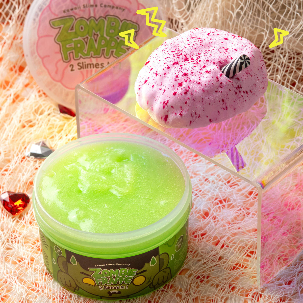 Front view of an open container of Zombie Frappe 2 Slimes in 1 with the brain and straw beside it.