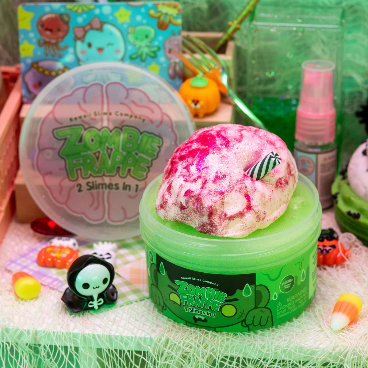 Front view of a decorated table with an open and put together container of Zombie Frappe 2 Slimes in 1.