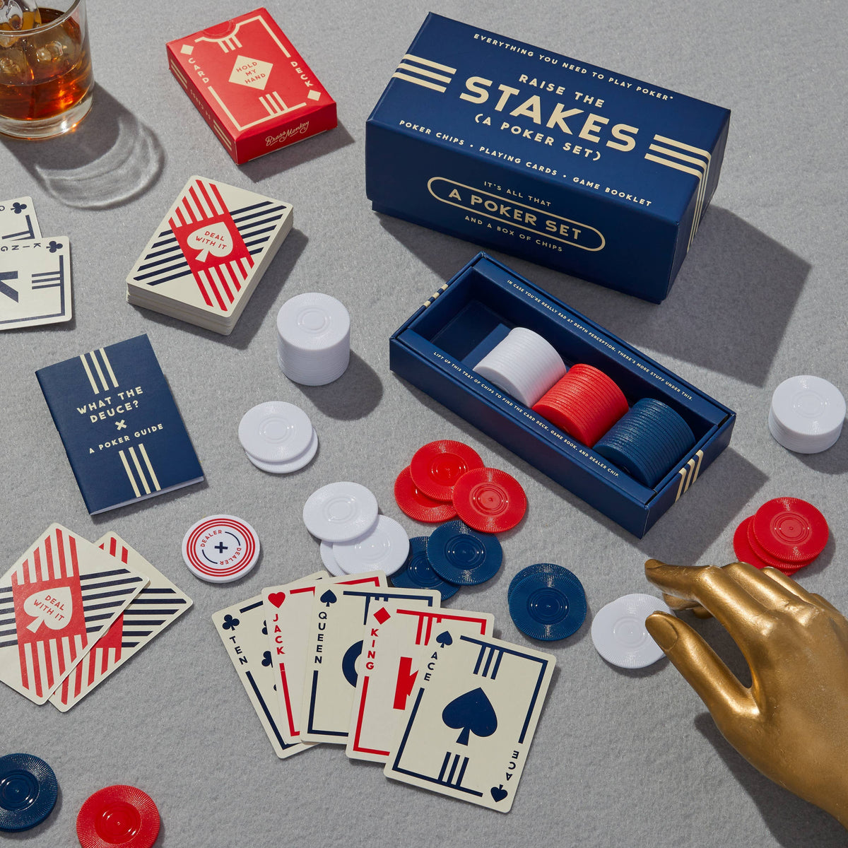 Front view of the Raise the Stakes Poker set and its contents laid out against a gray background.