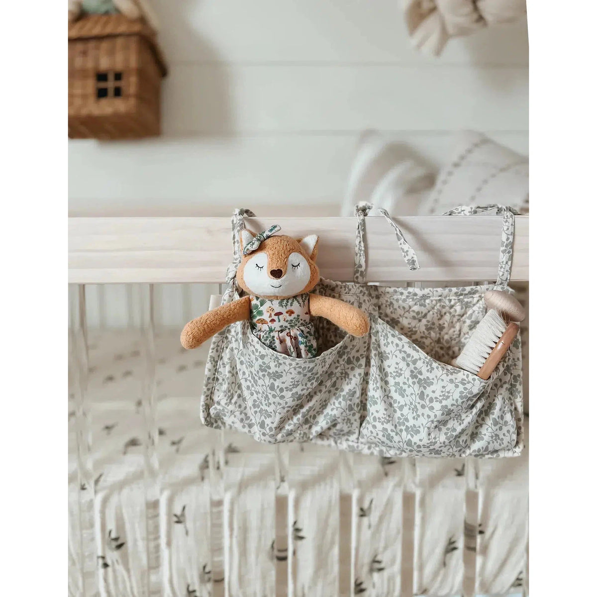 Front view of Little Fox-Boho Woodland in a storage pocket attached to a crib standing.