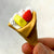 Front view of a person's fingers holding the dessert pizza from the Puzzle Eraser Card Set-Dessert.