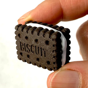 Front view of a person holding the cream filled chocolate biscuit from the Puzzle Eraser Card Set-Dessert.