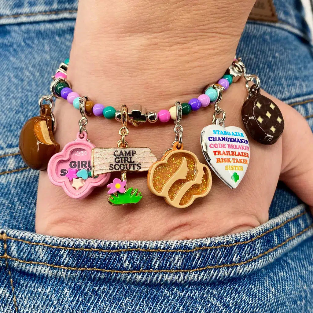 Front view of a person&#39;s hand wearing a charm bracelet with the Charm It-Girl Scout Thin Mints Charm on it.