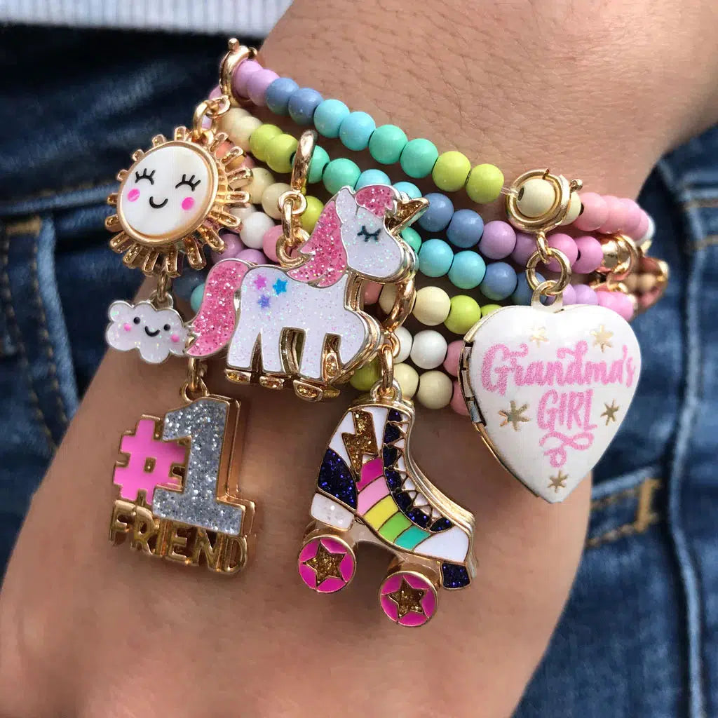 Front view of a persons hand wearing a charm bracelet with the Charm It-Gold Rainbow Rollerskate Charm.
