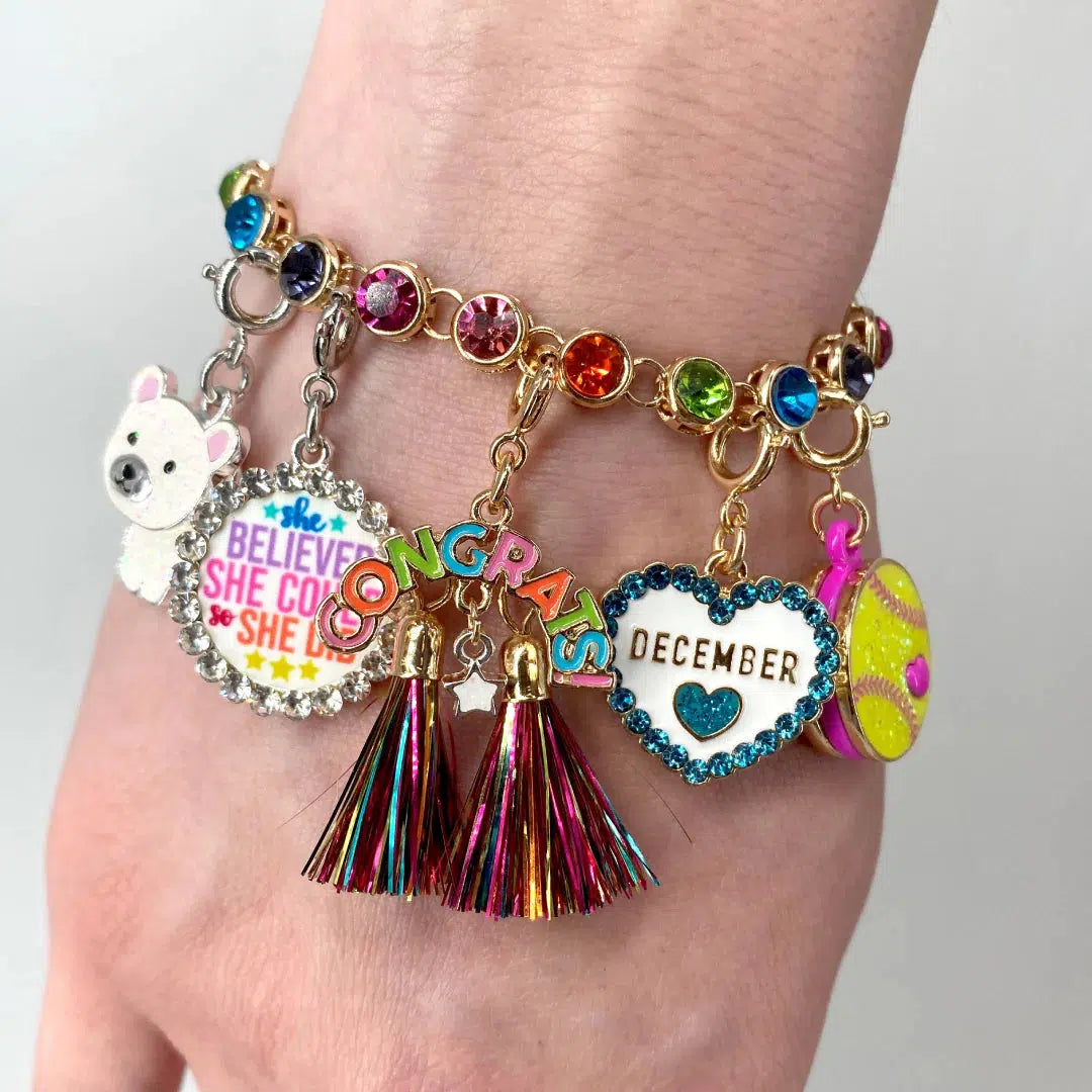 Front view of a person&#39;s wrist with a charm bracelet showing the Charm It-She Believed Charm on it.