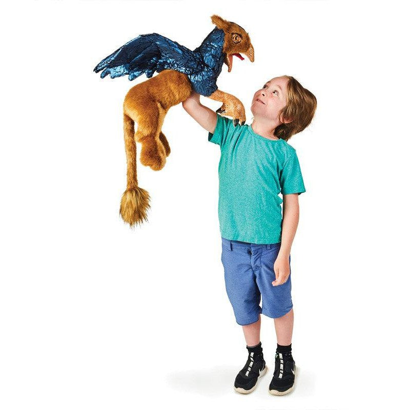 Front view of a young boy holding up the Griffin-Puppet.