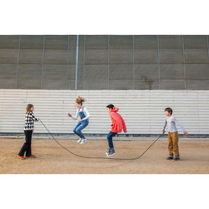 Front view of four young kids playing with the Playground Jump Rope.