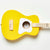 Front view of the yellow acoustic guitar turned sideways against a white background.