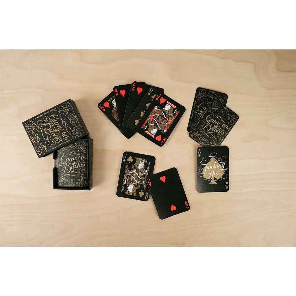 Front view of the contents from the Game On, Bitches card set laid out against a wooden background.