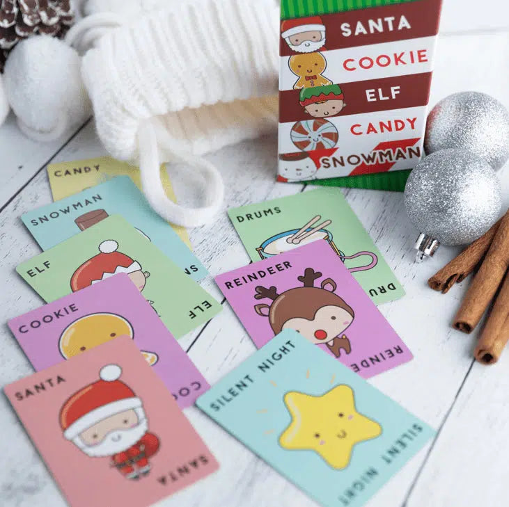 Front view of several cards from the Santa Cookie Elf Candy Snowman game laid in front of the box.