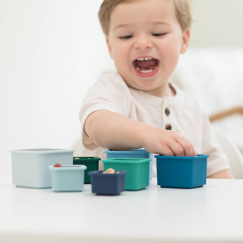 Front view of a baby playing with the Cool Blue Happy Stacks.