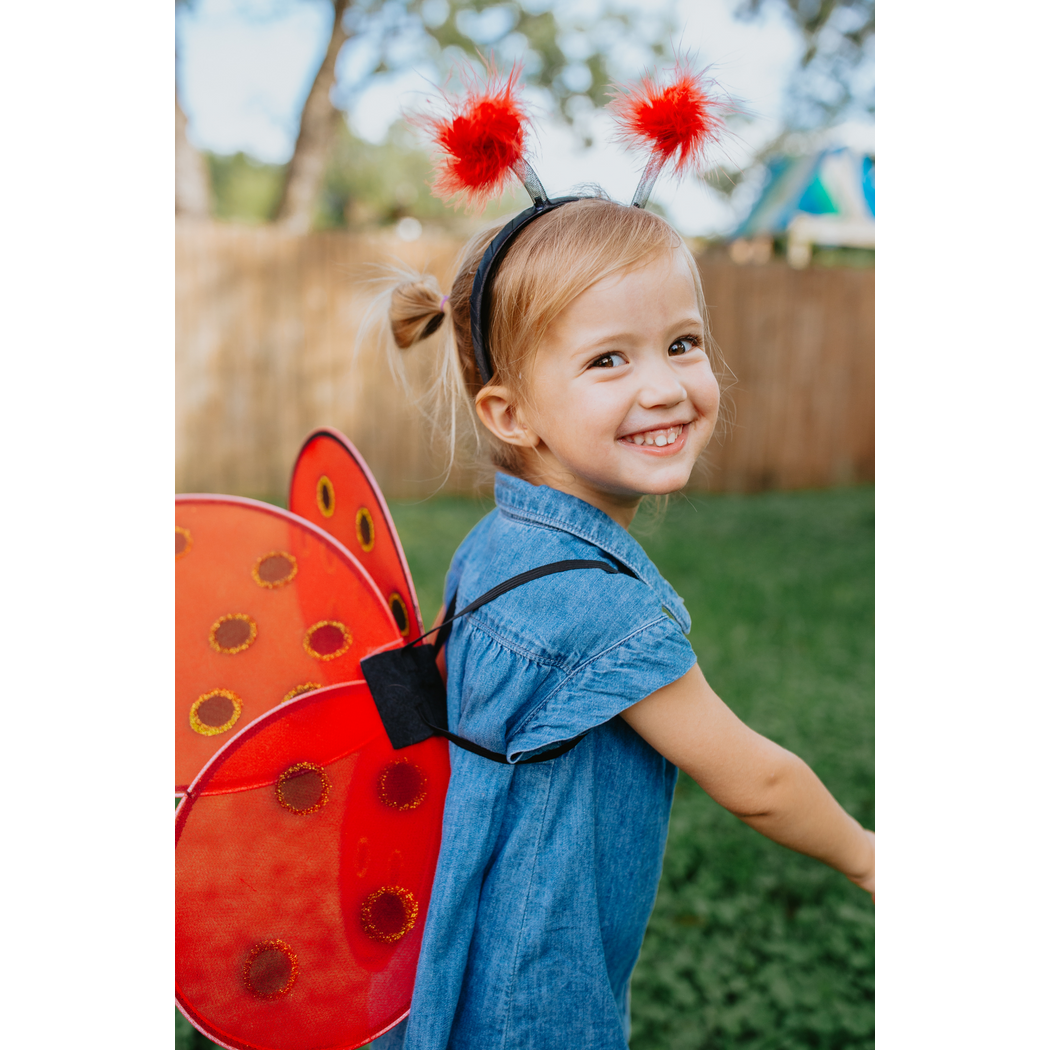 Smiling girl, 3/4 view of ladybug wings and headband
