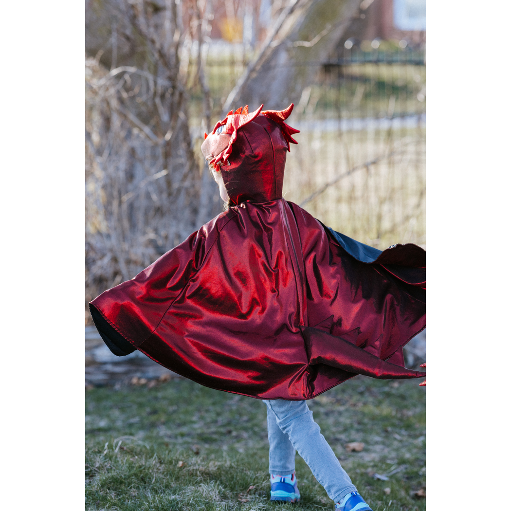 Rear view of running child wearing the dragon cape with hood on