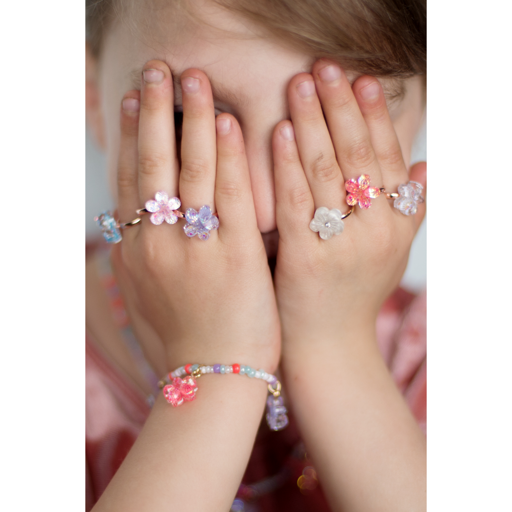 Child covering their eyes wearing the boutique shimmer flower rings