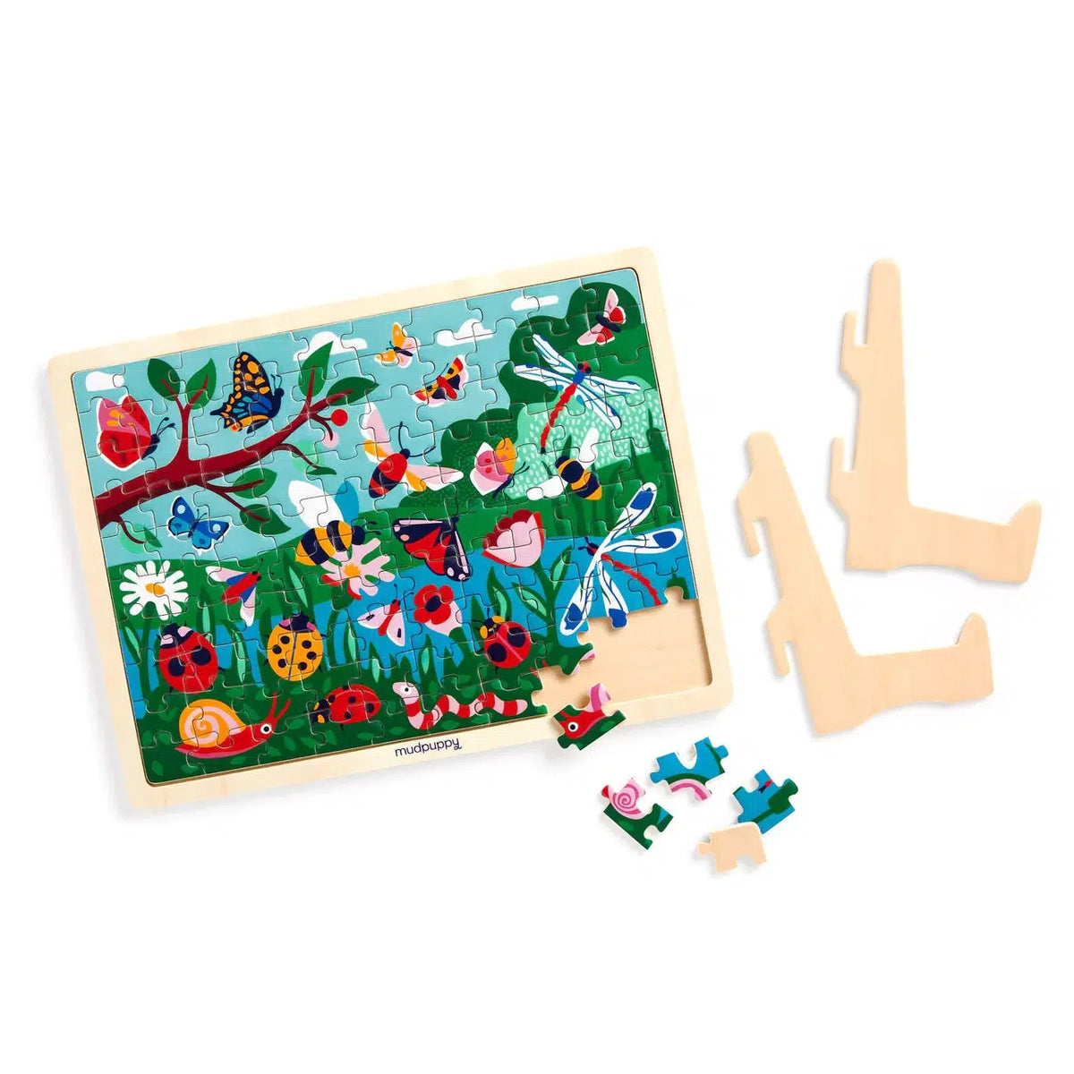 Front view of a mostly completed garden life puzzle, the missing pieces are scattered below the puzzle. To the right of the puzzle is the disassembled display stand.