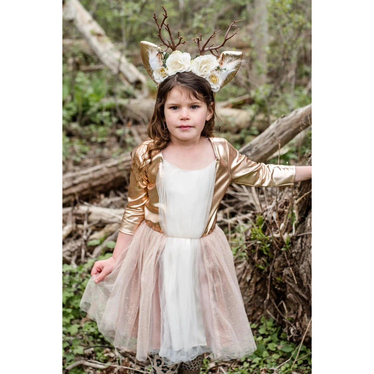 Girl standing in woods, wearing deer costume.