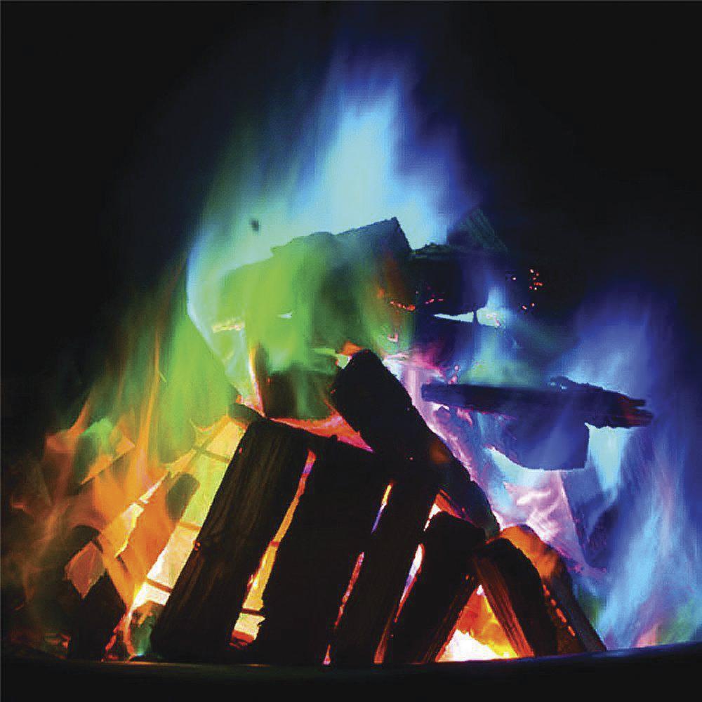 Front view of a person holding a packet of the Mystery Fire in their hand with different colored flames behind it.