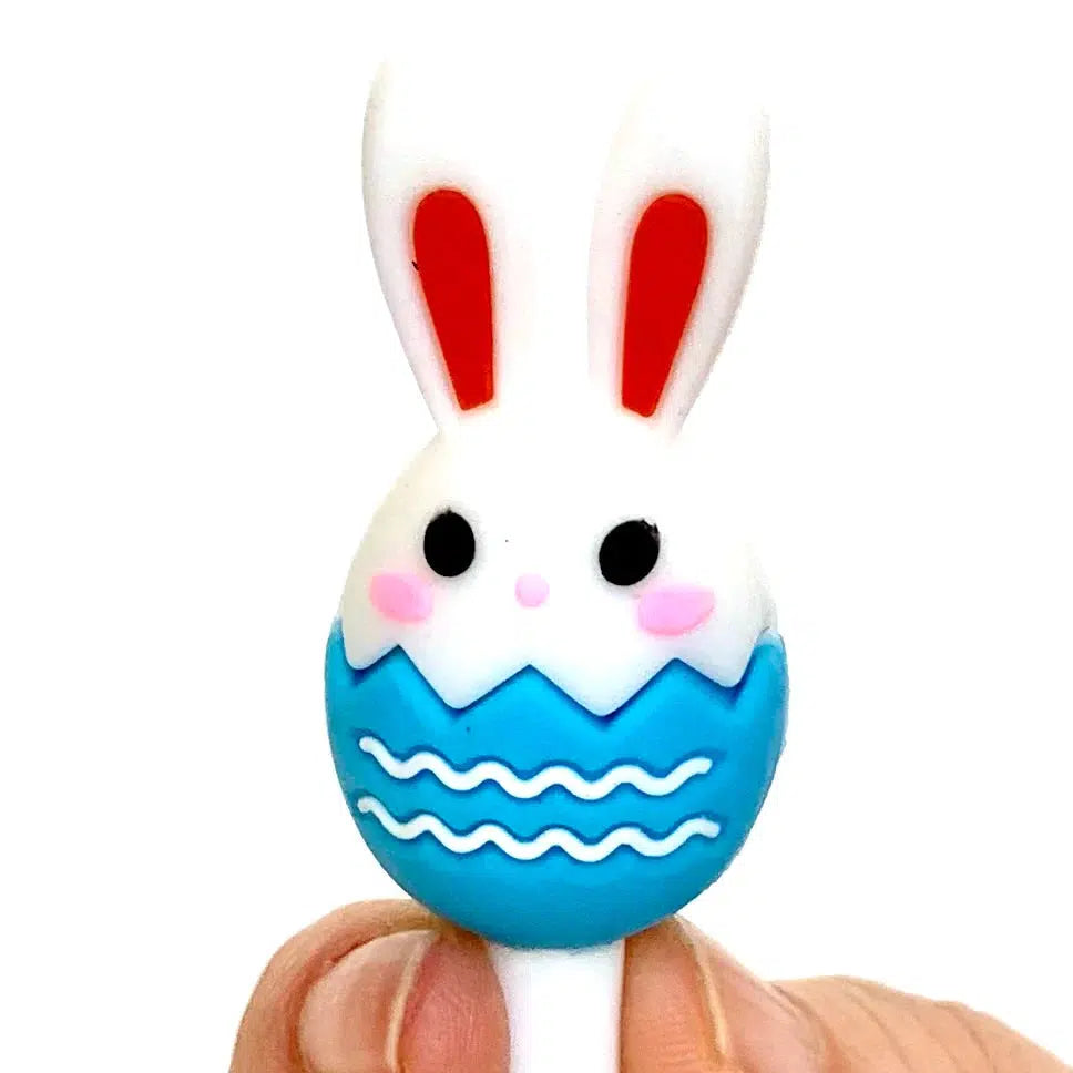 Front view of a person&#39;s fingers holding the blue Bunny Egg Gel Pen at the top showing the bunny head in the blue egg.