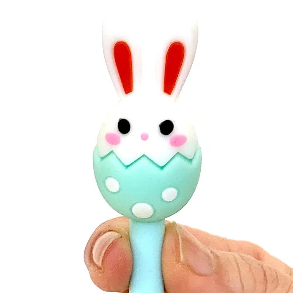 Front view of the mint green Bunny Egg Gel Pen being held in fingers towards the top showing the mint green egg with the bunny head in it.