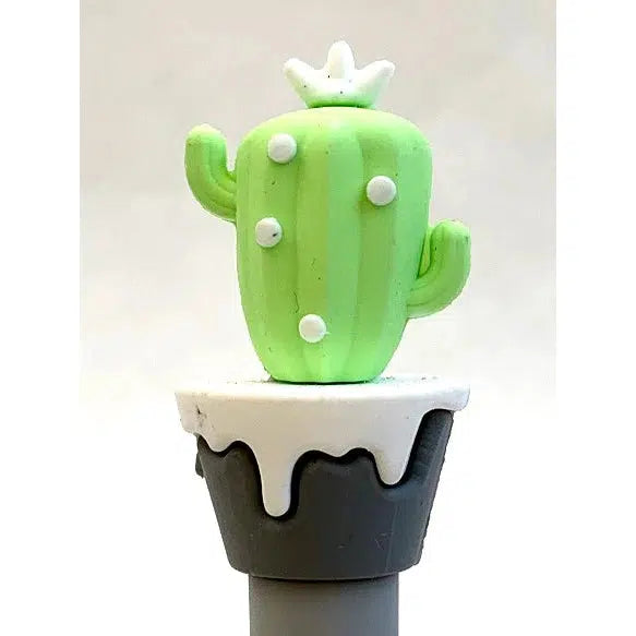 Front view of light green cactus sitting on top of black pot with white top on a gel pen.