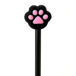 Front view of black cat paw with pink pads sitting on top of black gel pen.
