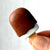 Front view of a person's fingers holding a chocolate Ice Cream Eraser.