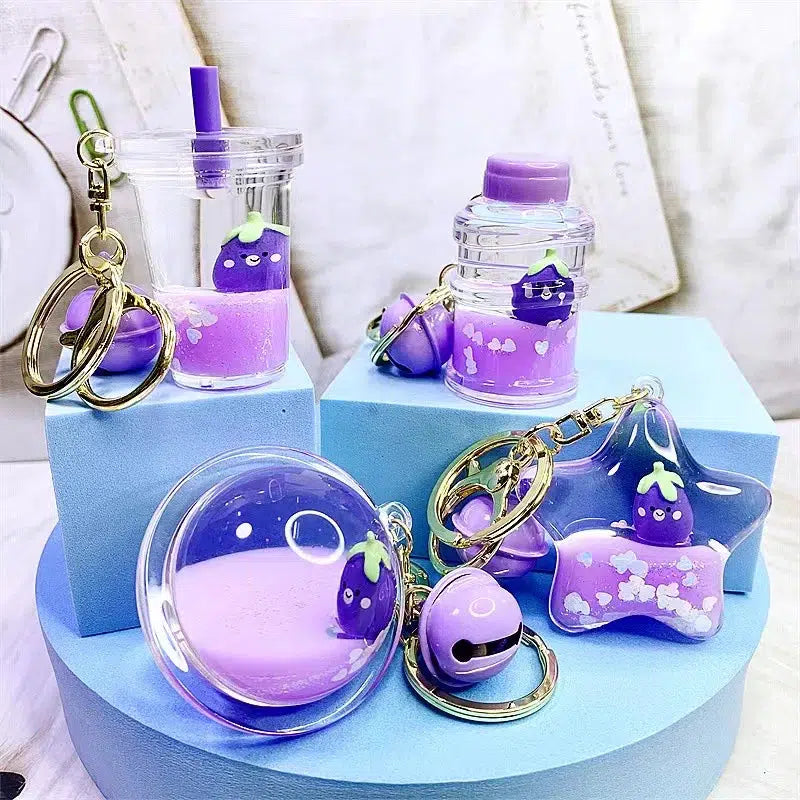 Front view of all the various styles of the Eggplant Floaty Key Charm on a blue display.