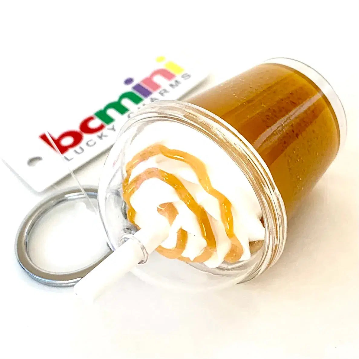 Front view of dark Iced Coffee Key Charm laying on its side.