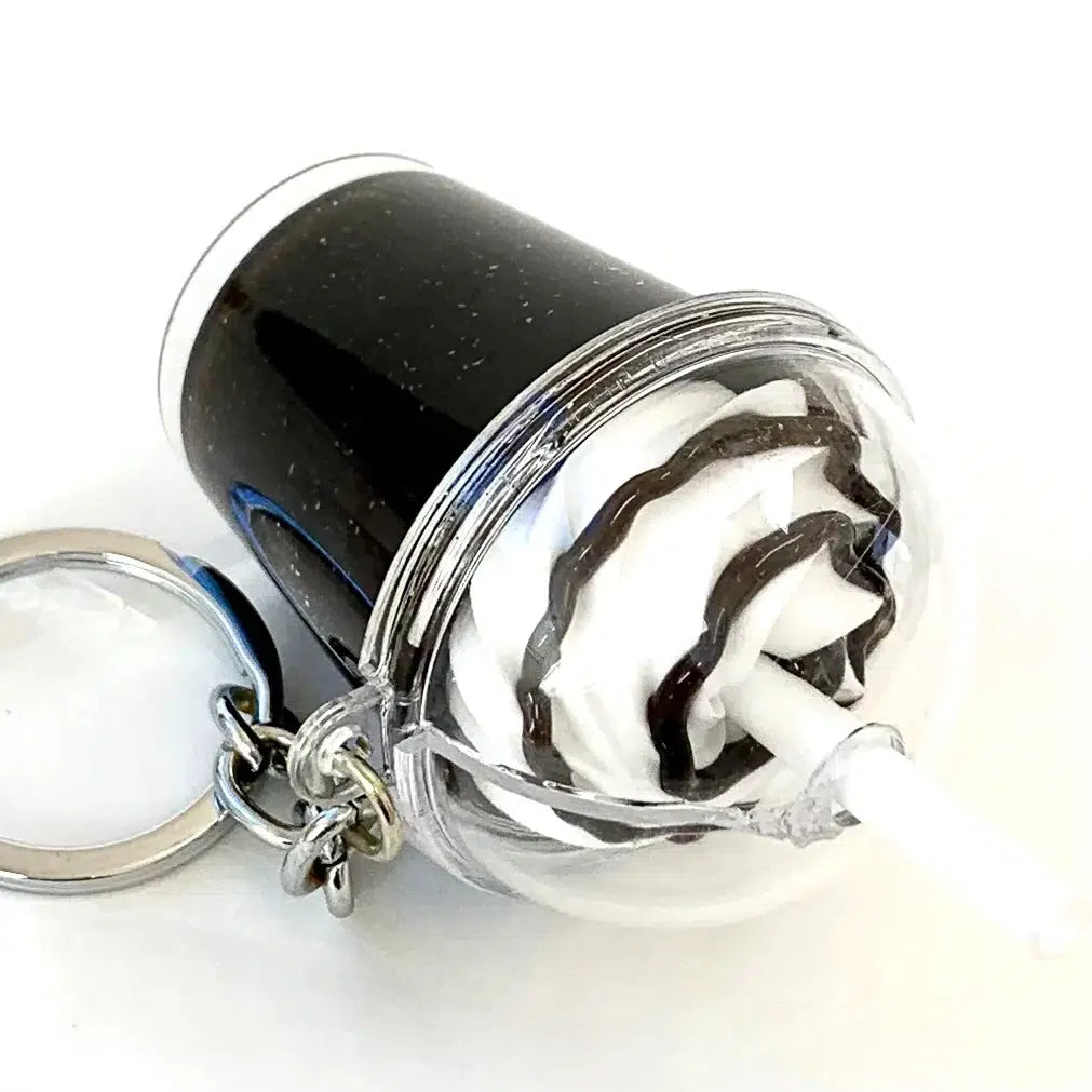Front view of dark Iced Coffee Key Charm laying on its side.
