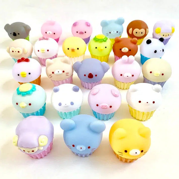 Front view of various animals sitting on top of various colored cupcakes.