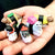 Front view of a person's hand holding 5 various styles of sushi cats in palm of hand.