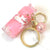 Front view of a Unicorn Love Floaty Key Charm laying on its side so you can see the pink ball o the key charm part as well as the pink liquid in the bottle.