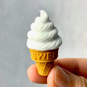 Front view of a person's fingers holding a vanilla Ice Cream Eraser.