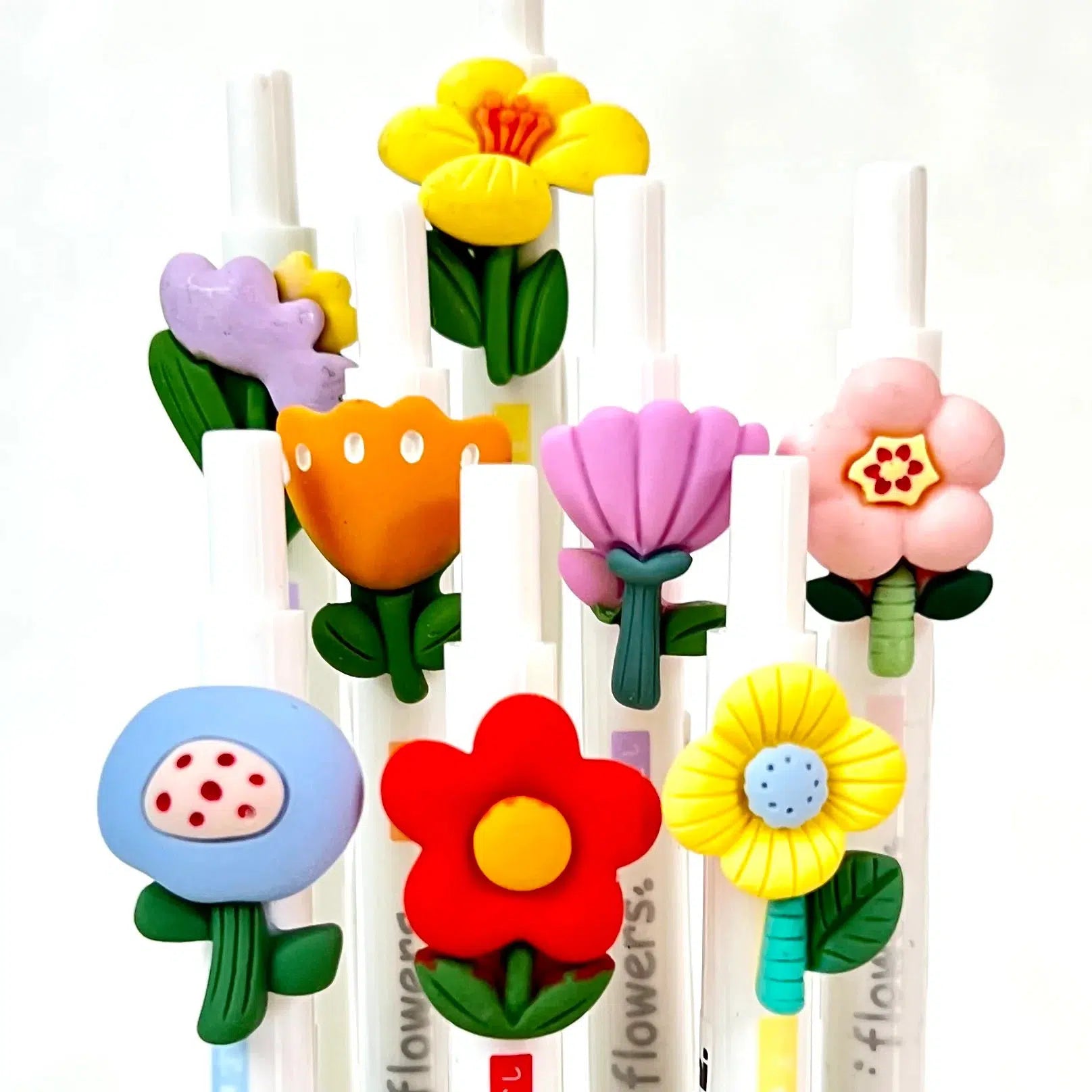 Front view of multiple styles of flower pens against a white background.