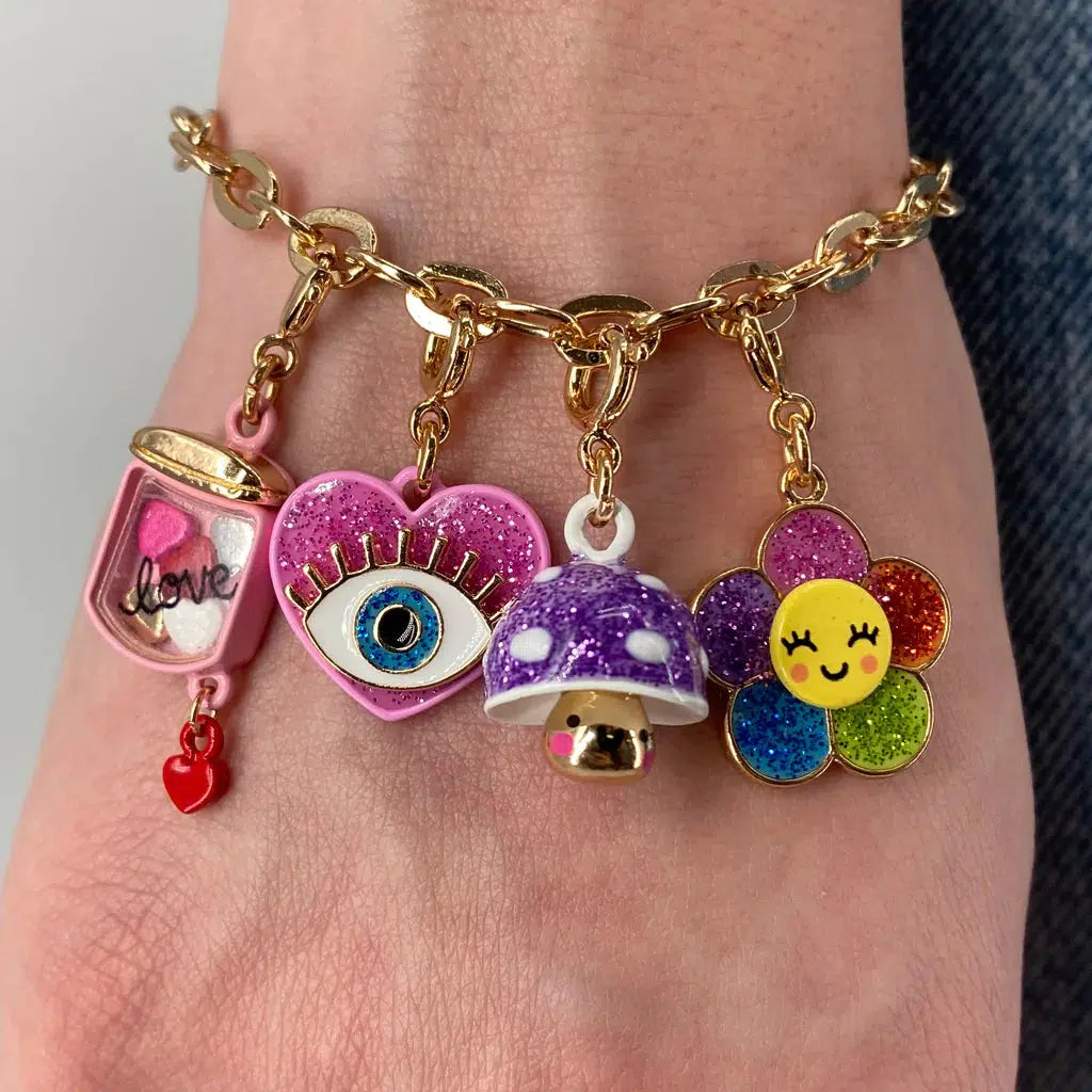 Front view of a person wearing a charm bracelet with the Gold Glitter Mushroom Charm on it.