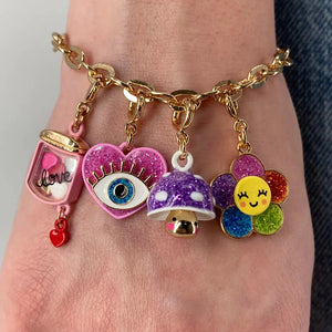 Front view of a person with a charm bracelet on that has the Gold Glitter Lucky Eye Charm on it.