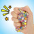 Front view of a hand holding and squeezing PokeN Dots thinking putty.