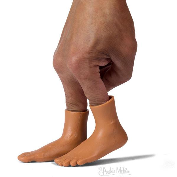 Front view of a darker skin tone hand and Finger Feet puppets showing on two fingers on the hand.