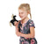 Front view of a little girl with the mini black unicorn finger  puppet on her finger while she is holding her arm up with her other hand.