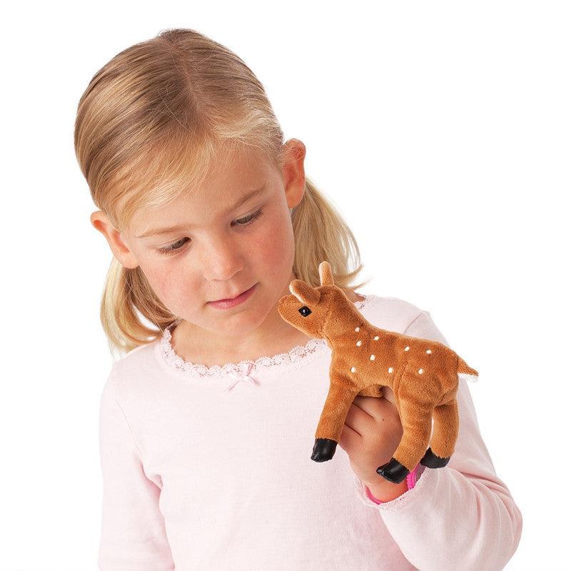 child holding mini fawn on finger
