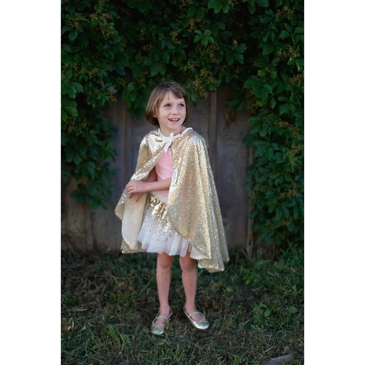 Front view of a child in the Gracious Gold Sequin Cape.