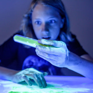 Front view of child examining an experiment included in the luminescent lab.