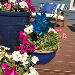 Front view of a porch with a Teal Mylar Pinwheel in a flowerpot.
