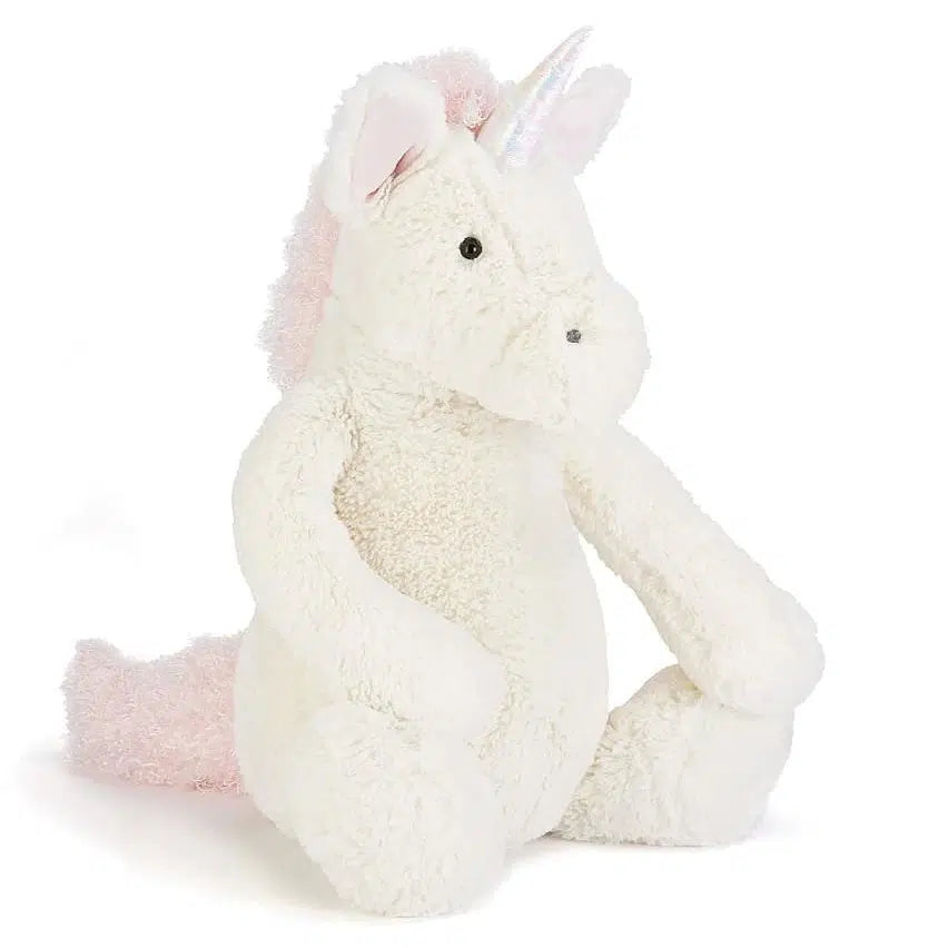 Front slight right side view of huge bashful unicorn sitting down.