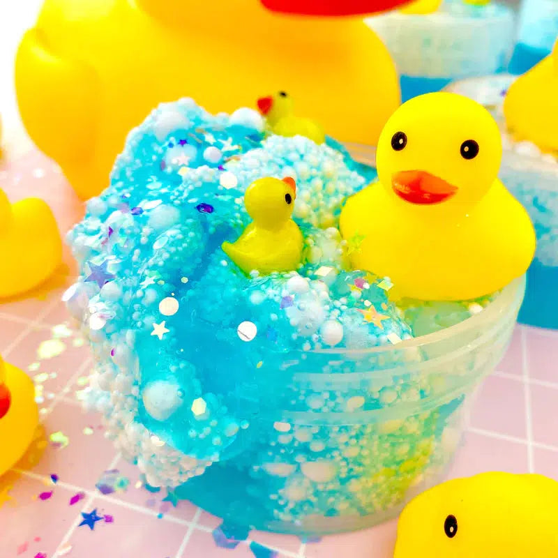 Front view of Squeaky Clean Bubble Bath Floam Slime after it has been opened and decorated with ducks and beads.