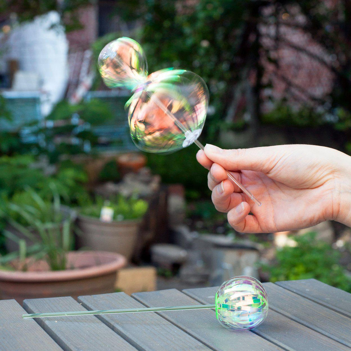 Iridescent plastic strips twirled around a stick, forming a mesmerizing hourglass shape