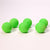 Front view of six green mischief maker refill balls lined up in two rows.