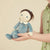 Front view of Betsy Blueberry Doll being held in a child's hands.